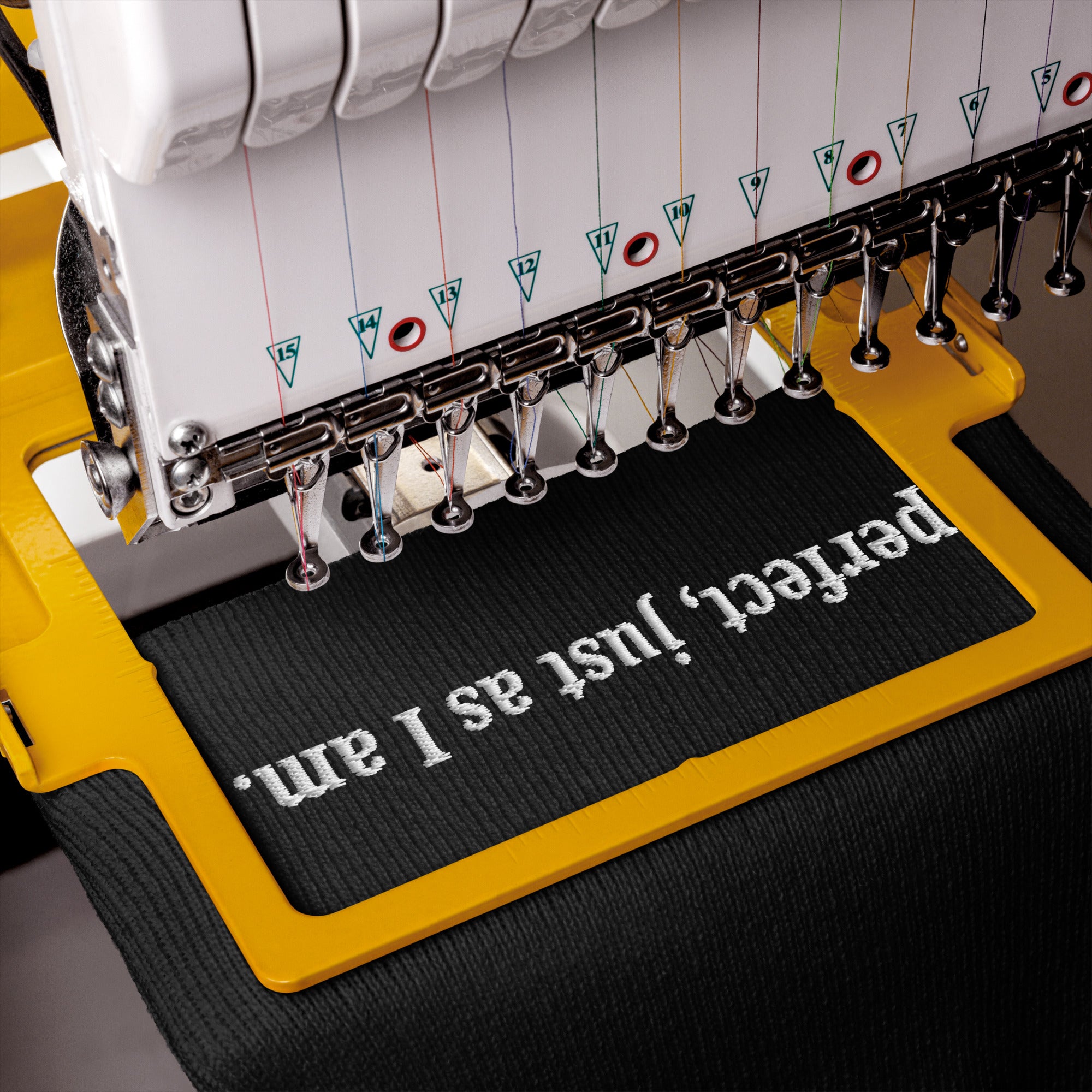 Embroidery machine with text 'perfect, just as I am' on a black knit hat