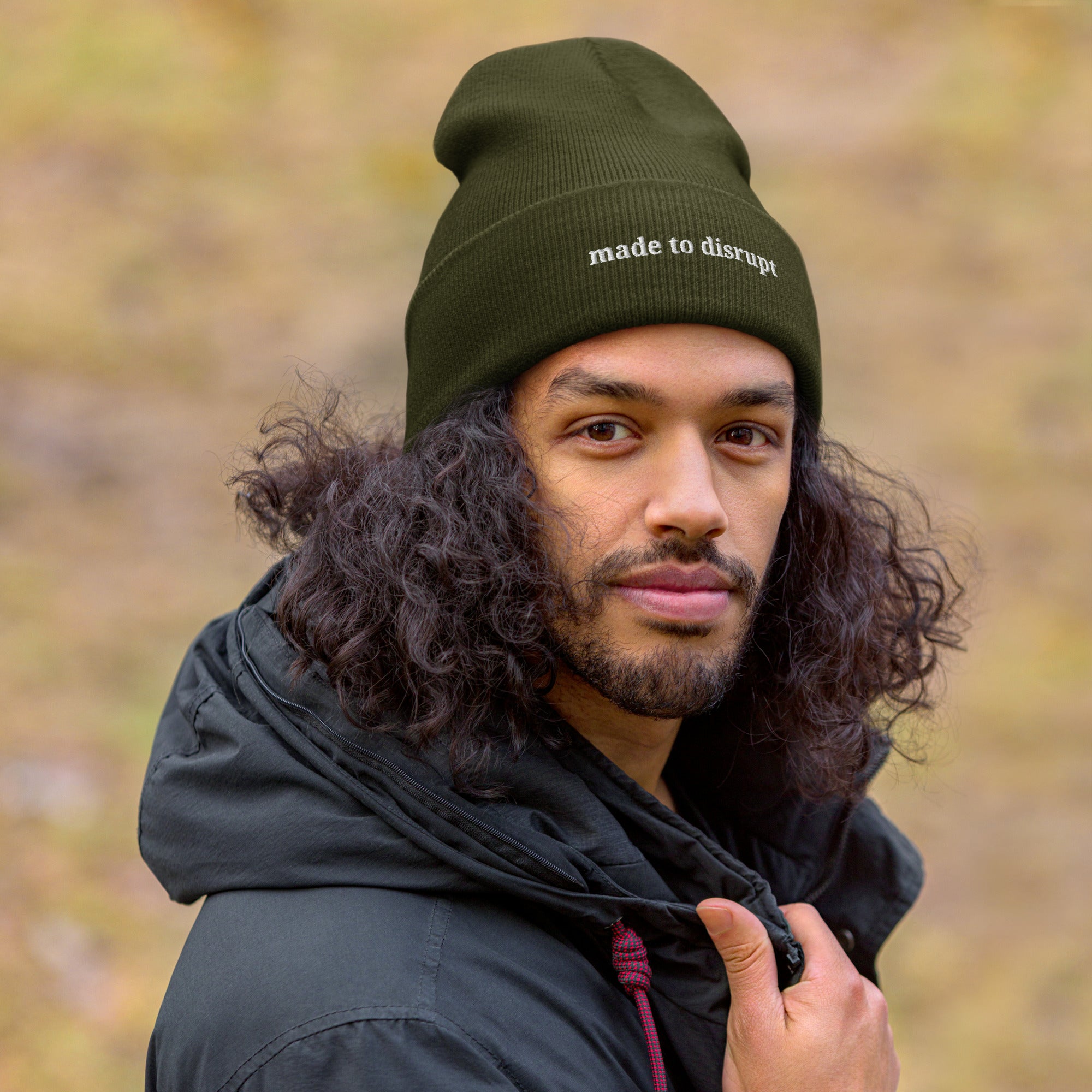 person wearing Made to Disrupt embroidered olive beanie from Nyxhera Creations, minimalist winter outfit