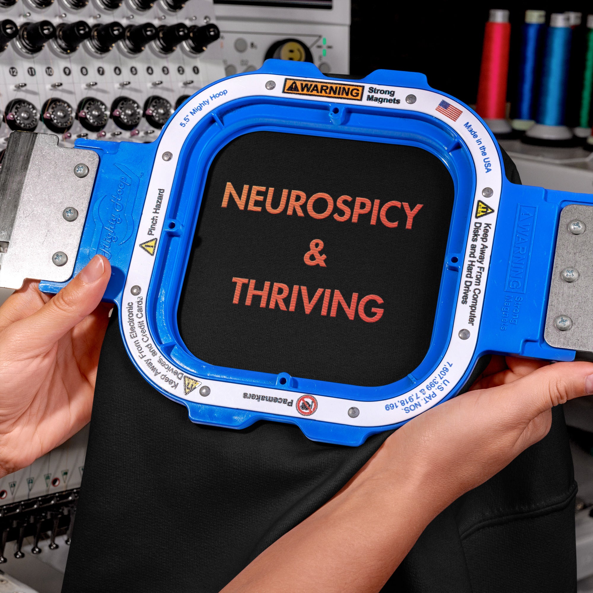 Close up of detailed red-to-orange gradient embroidery reading Neurospicy and Thriving