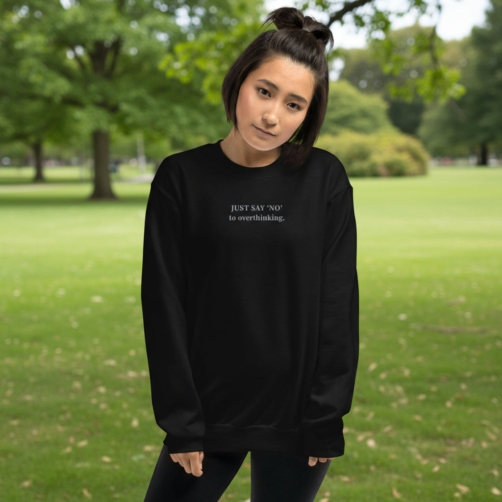 Unisex sweatshirt in black with embroidered text “Just Say No to Overthinking” in light grey thread.