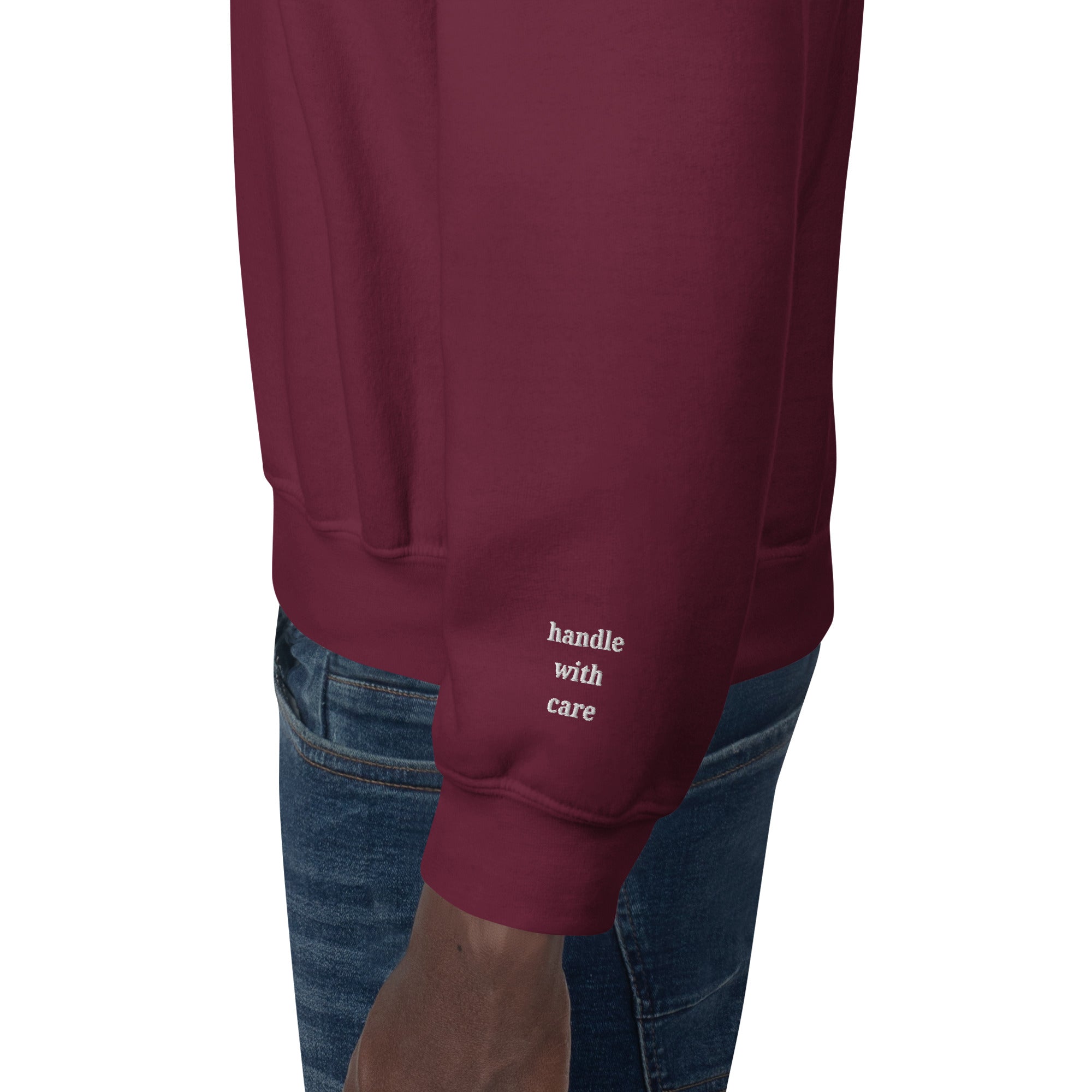 Cuff detail close up of embroidered cuff text Handle with care in white thread