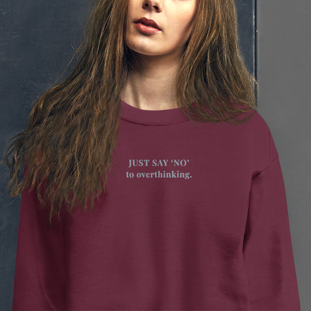 Unisex sweatshirt in maroon with embroidered text “Just Say No to Overthinking” in light grey thread.