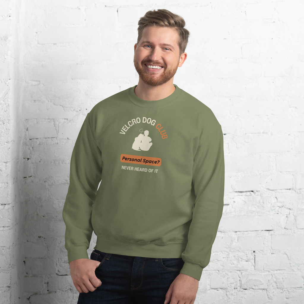 Man wearing a green sweatshirt with a graphic design against a white brick wall.