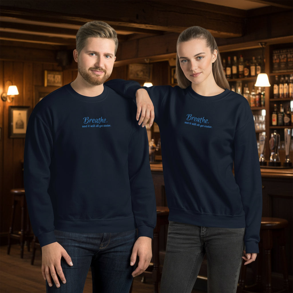 Male and female models wearing the “Breathe and It Will All Get Easier” embroidered navy sweatshirt, styled for everyday comfort and mindfulness.