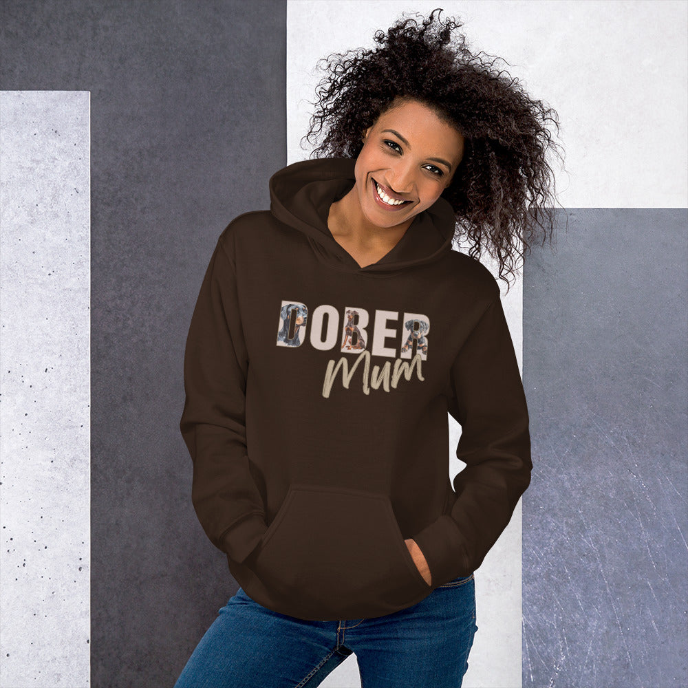 Woman wearing a brown hoodie with 'DOBER Mum' text against a gray and white background