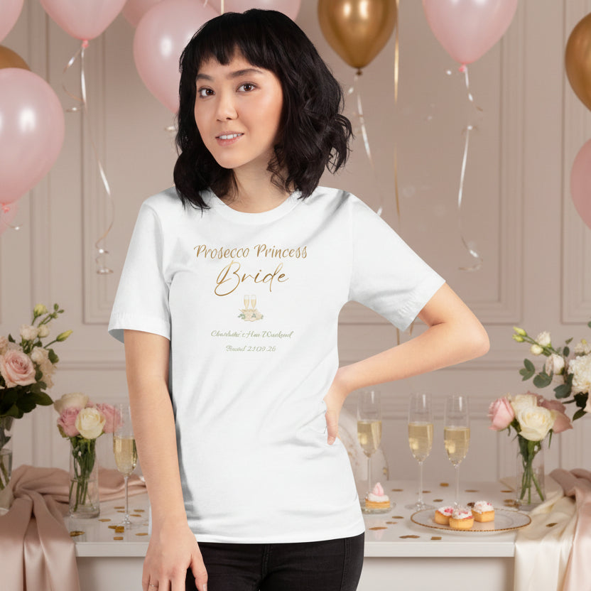 White bride t-shirt with “Prosecco Princess” metallic-effect text, floral accents and prosecco glass details for a hen party.