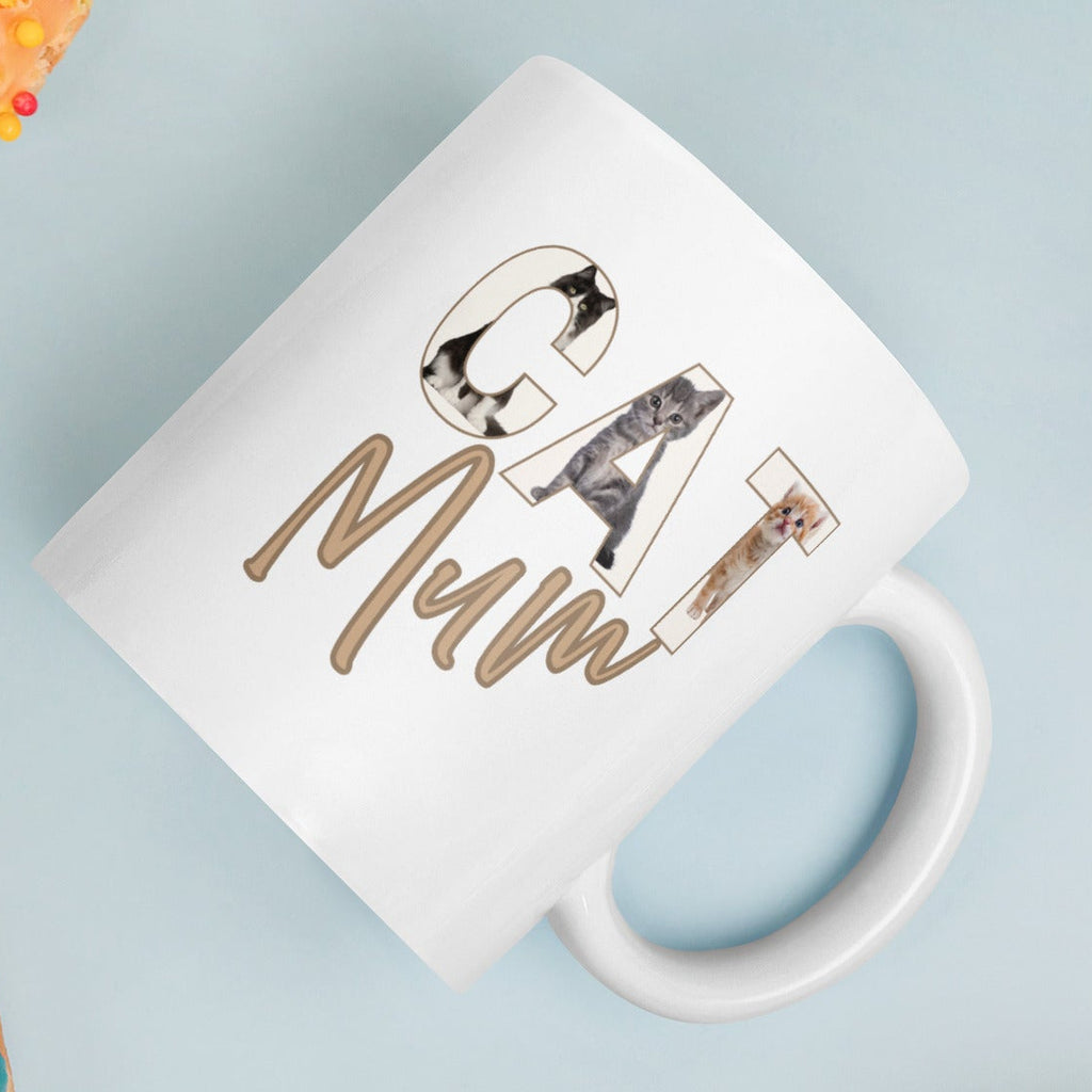 Close-up of illustrated cats in letters forming the word CAT on white mug