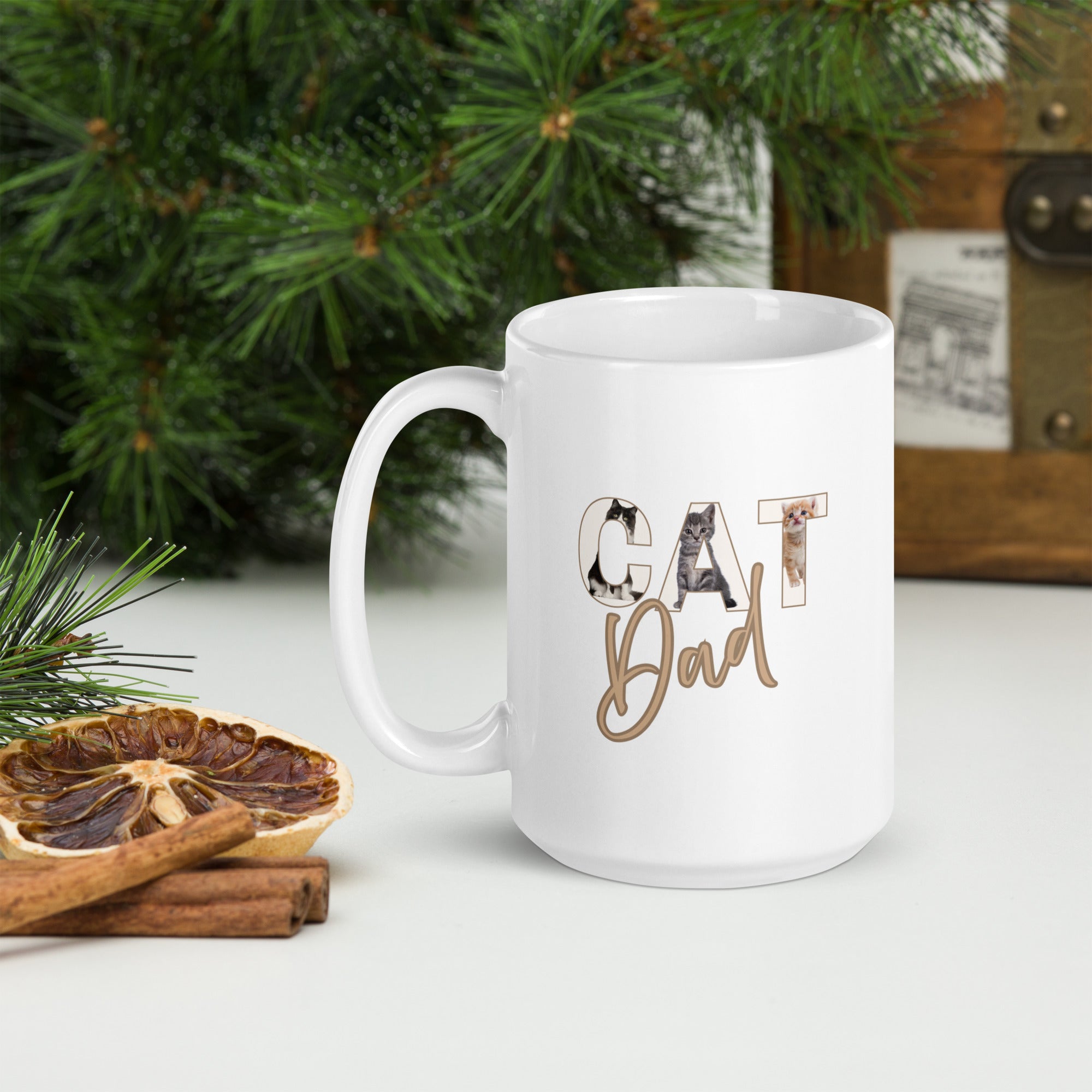 White mug with 'Cat Dad' text on a table with Christmas decorations