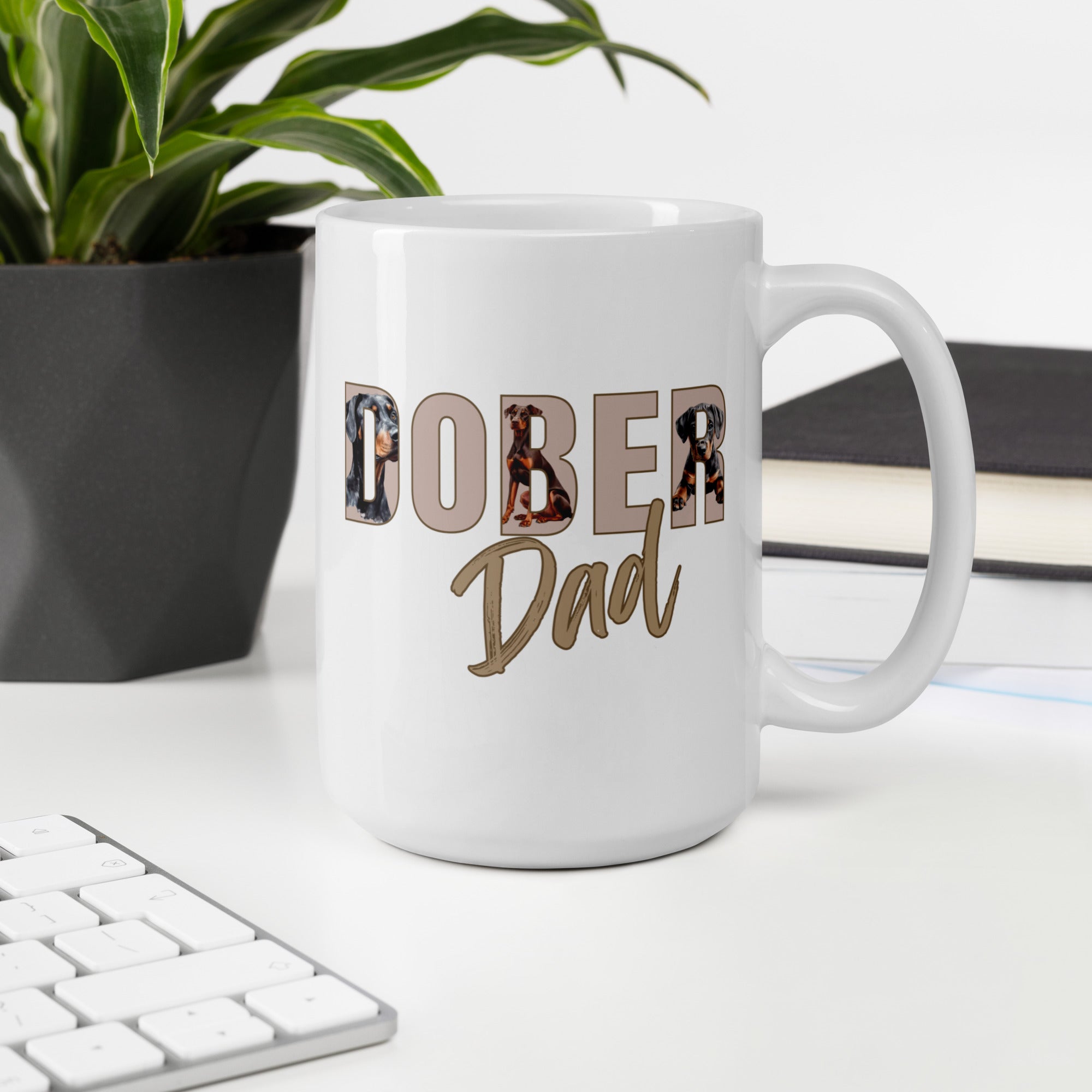 White mug with 'Dober Dad' text on a desk with a plant and books in the background